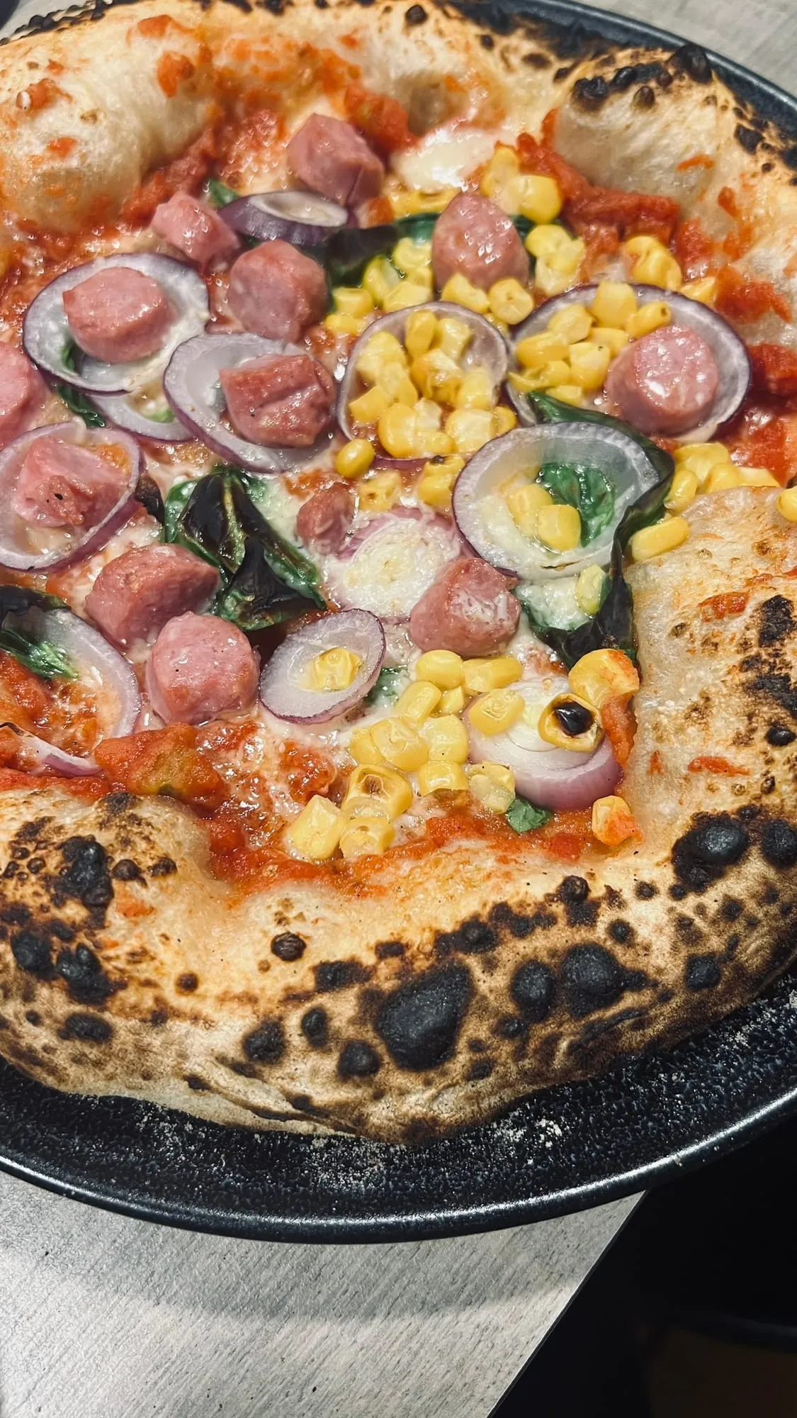 Pizza mit Würstel und Mais